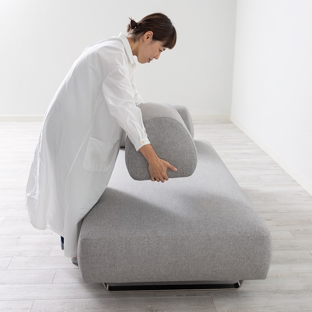 Reposの座面に背クッションを置こうとする人