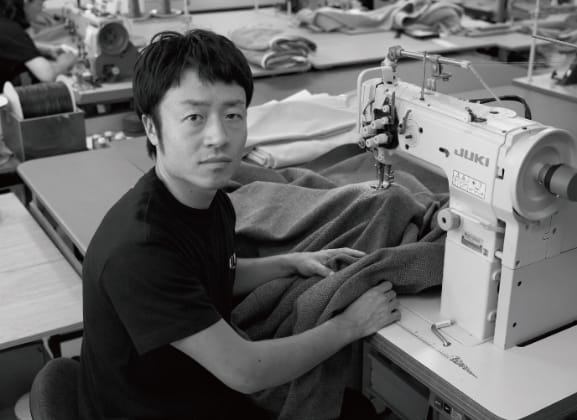 ソファ生地を縫製する職人